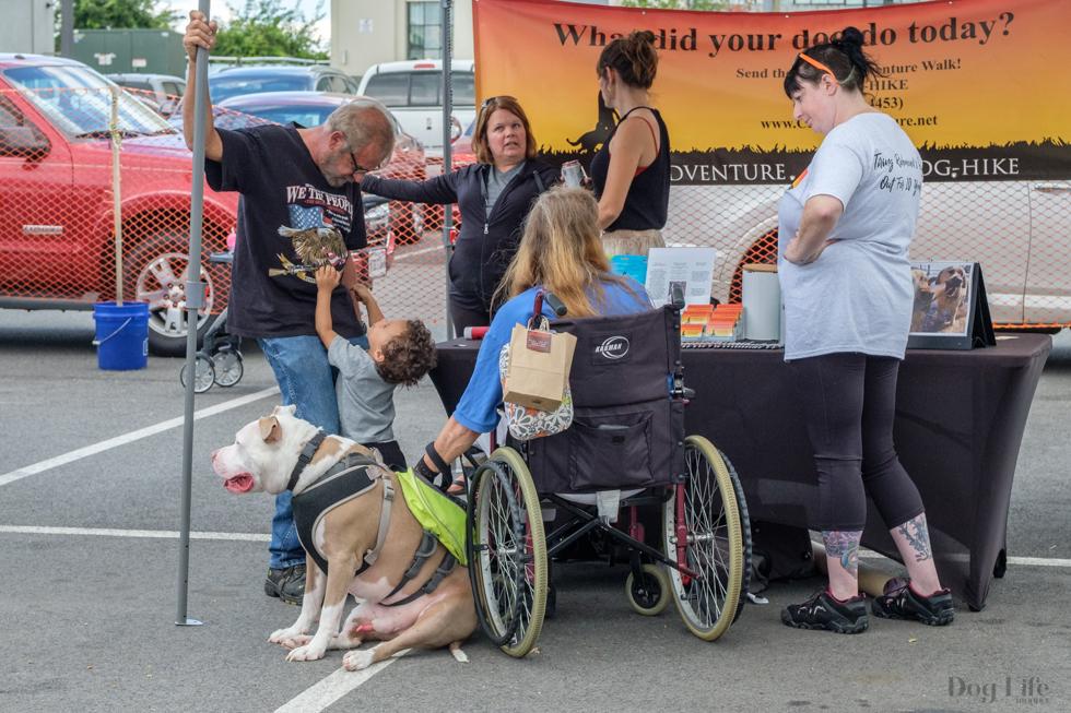 A group of people standing around a table with a sign that says