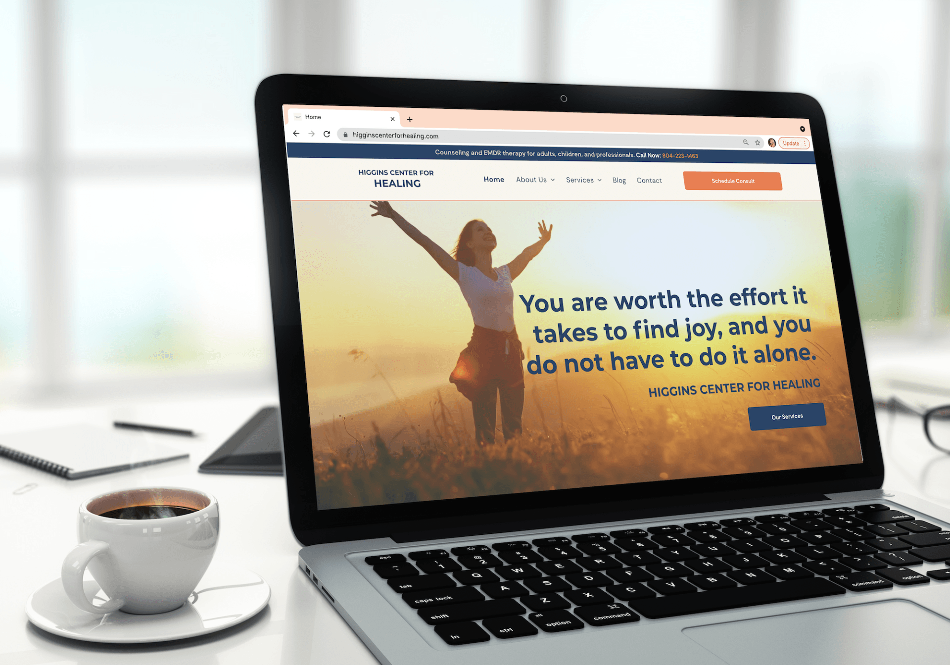 A laptop computer is sitting on a desk next to a cup of coffee.