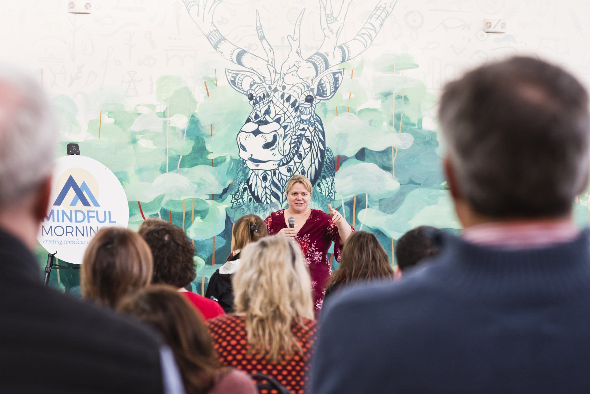 A woman is giving a speech in front of a crowd of people.