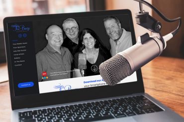 Laptop screen showing podcast hosts, a microphone in front.