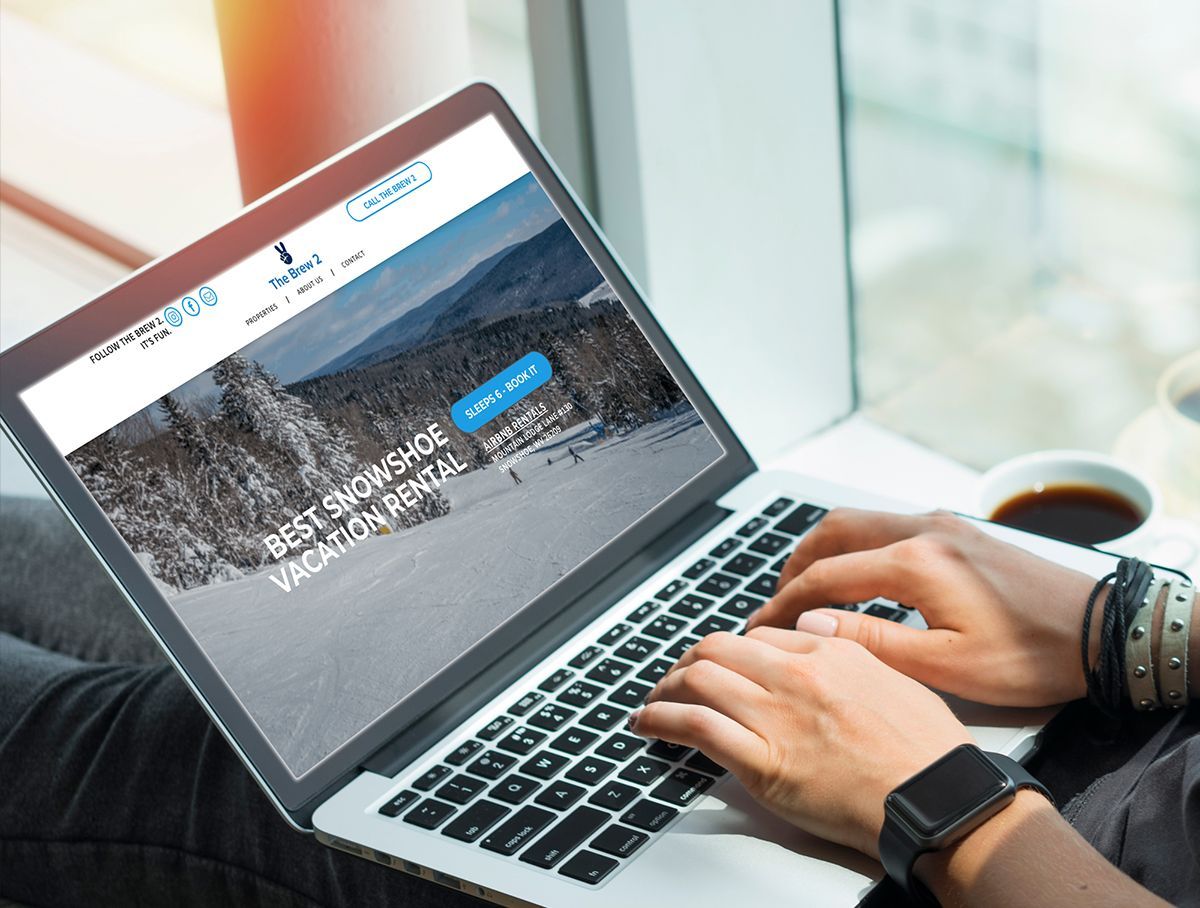 a person is typing on a laptop with a website on the screen