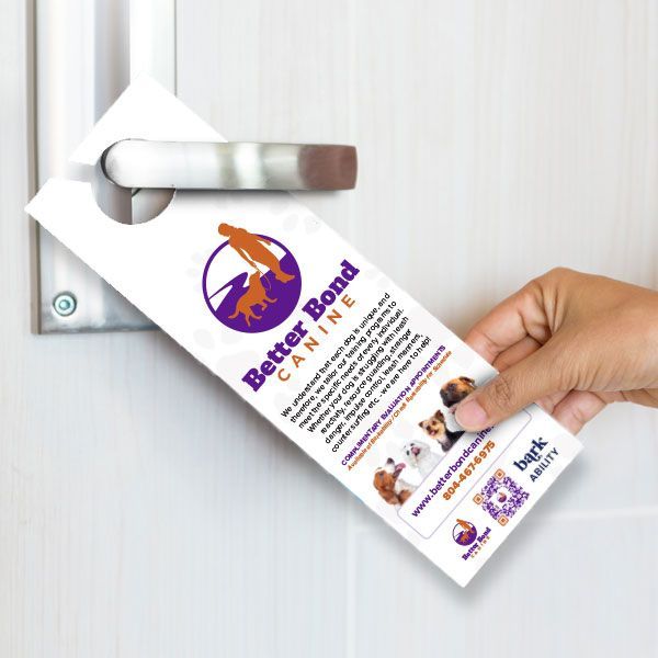 Hand placing a door hanger for Better Bond Canine on a door handle.