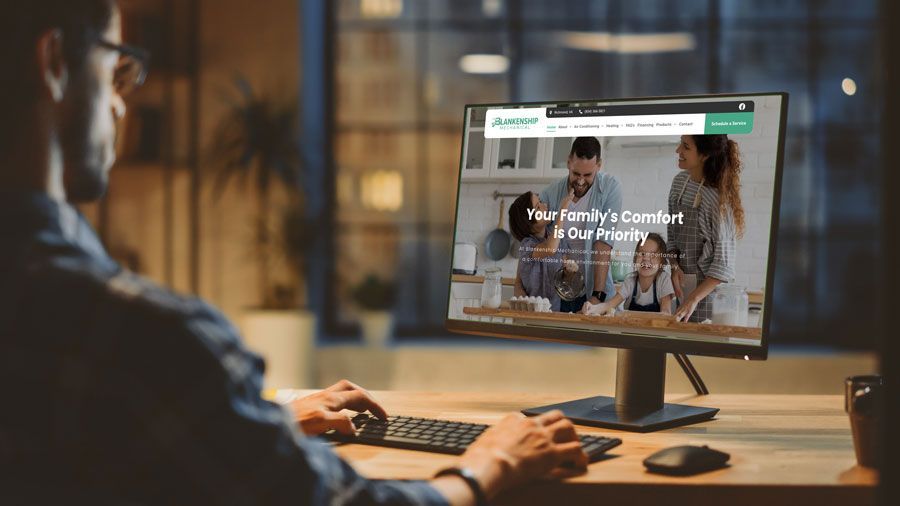 A man is sitting at a desk using a computer.
