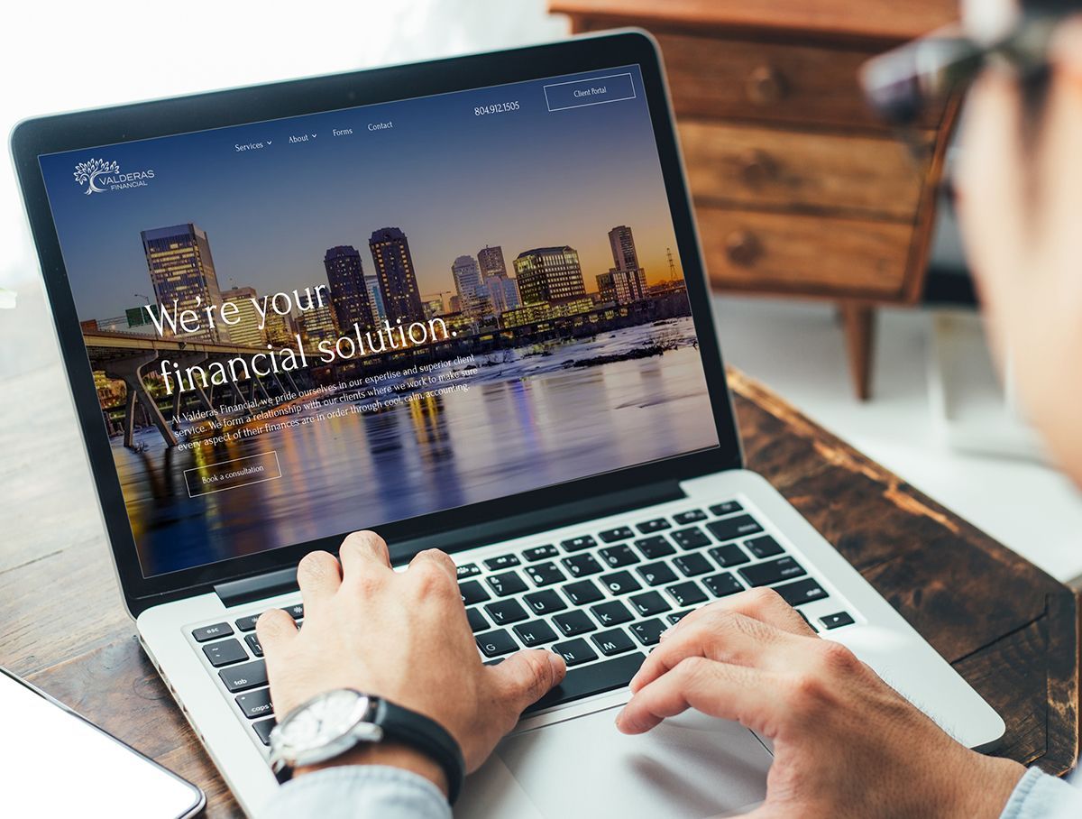 a person is typing on a laptop computer with a website on the screen