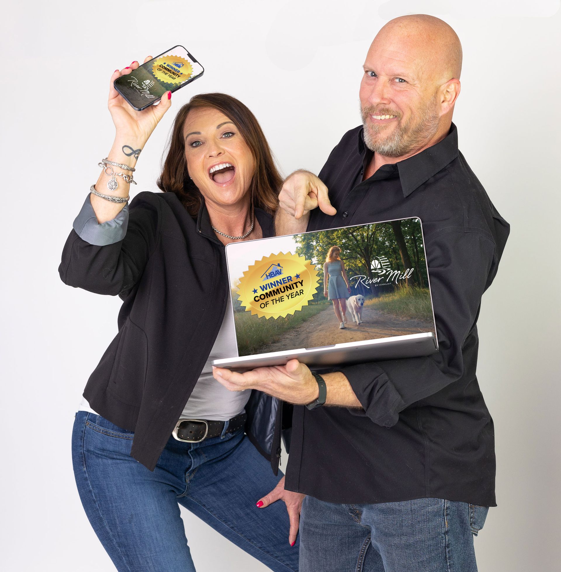 A man and a woman are holding a book and a cell phone