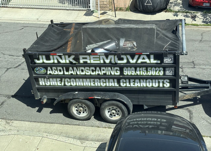 A&D dump trailer with the bed raised, on a dirt surface.