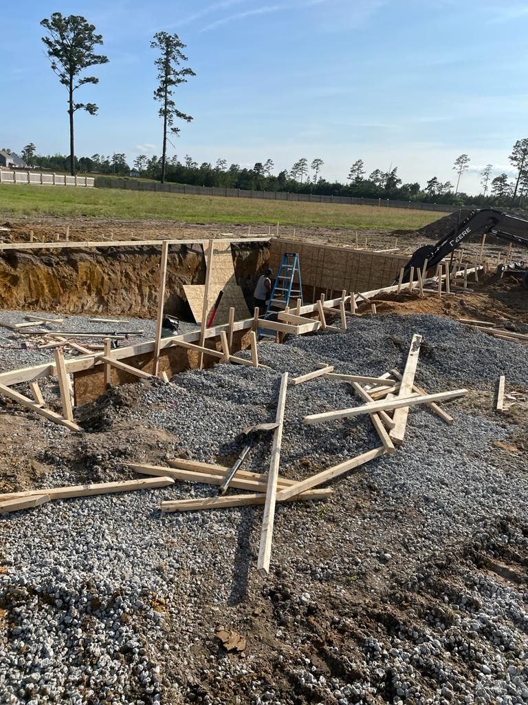 A construction site with a lot of gravel and wooden scaffolding.