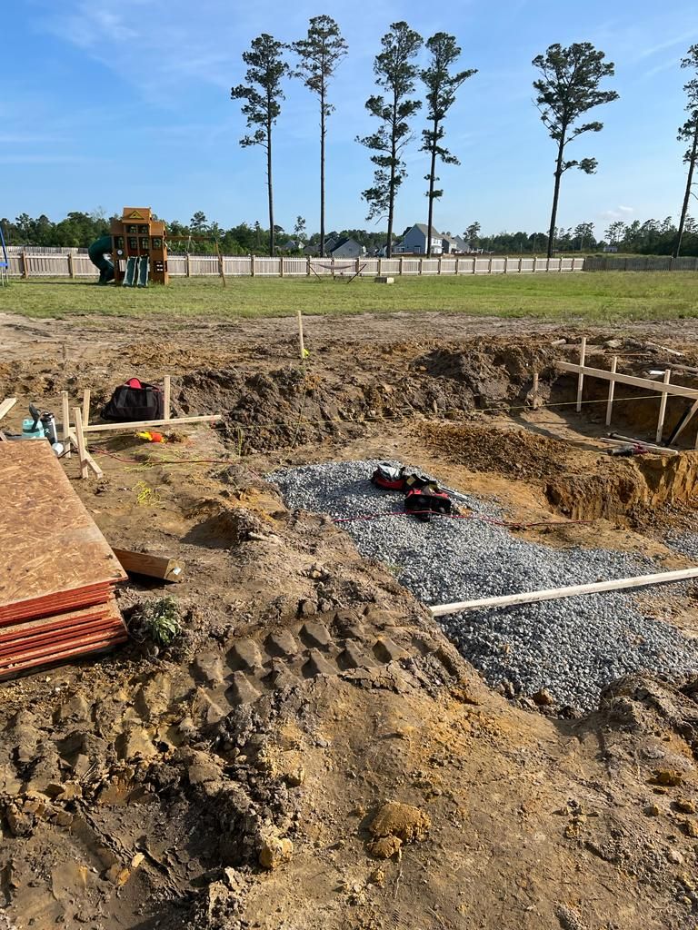 A construction site with a playground in the background.