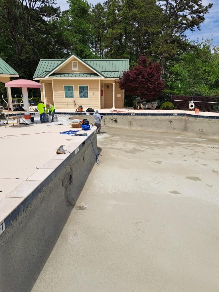 A swimming pool is being remodeled in front of a house.