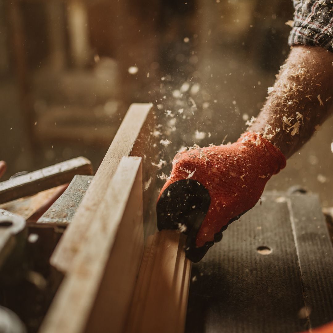 A person is cutting a piece of wood with a saw.