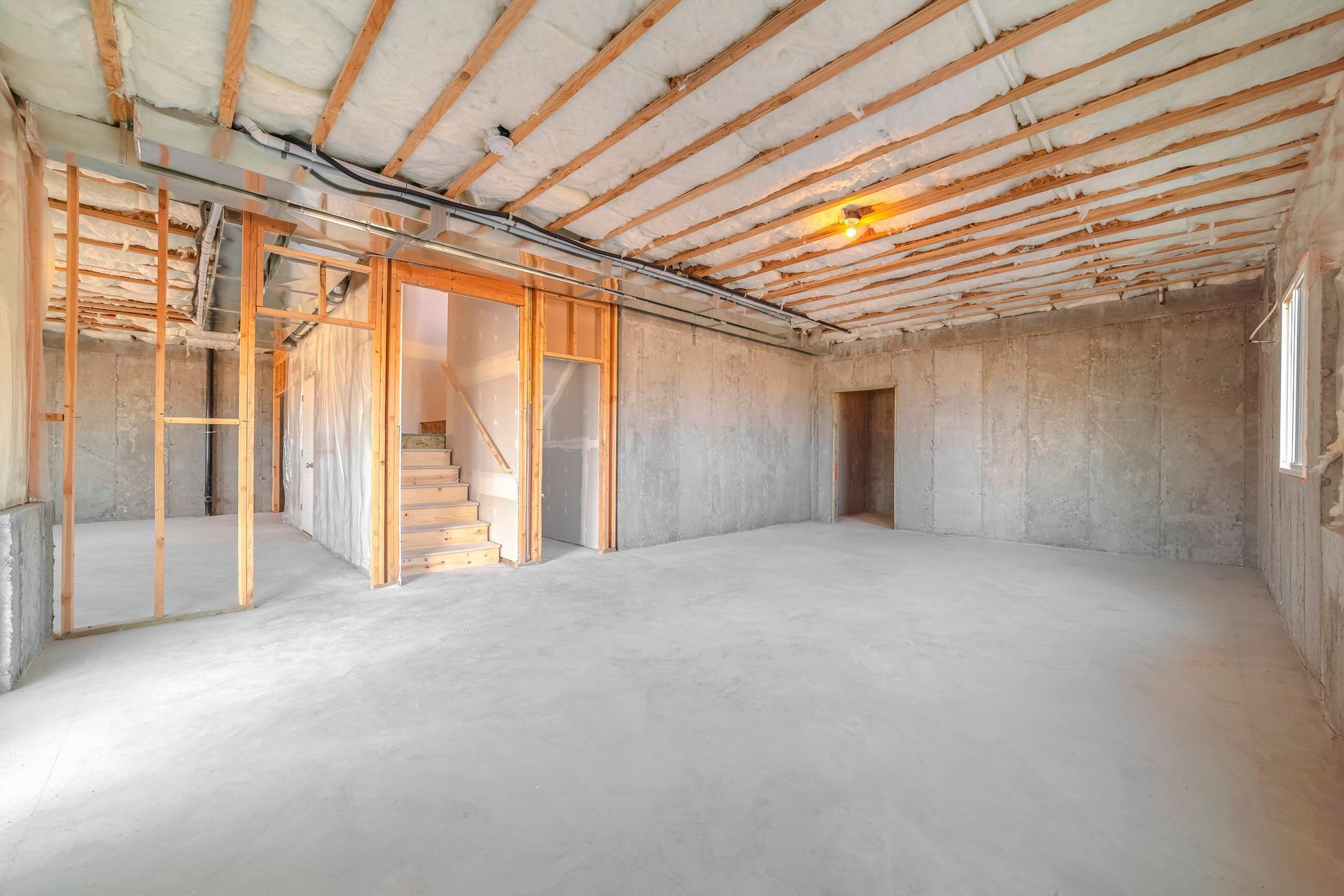 An empty basement in a house under construction with wooden beams.