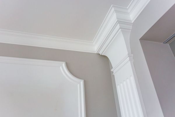 A close up of a white molding on a wall in a room.