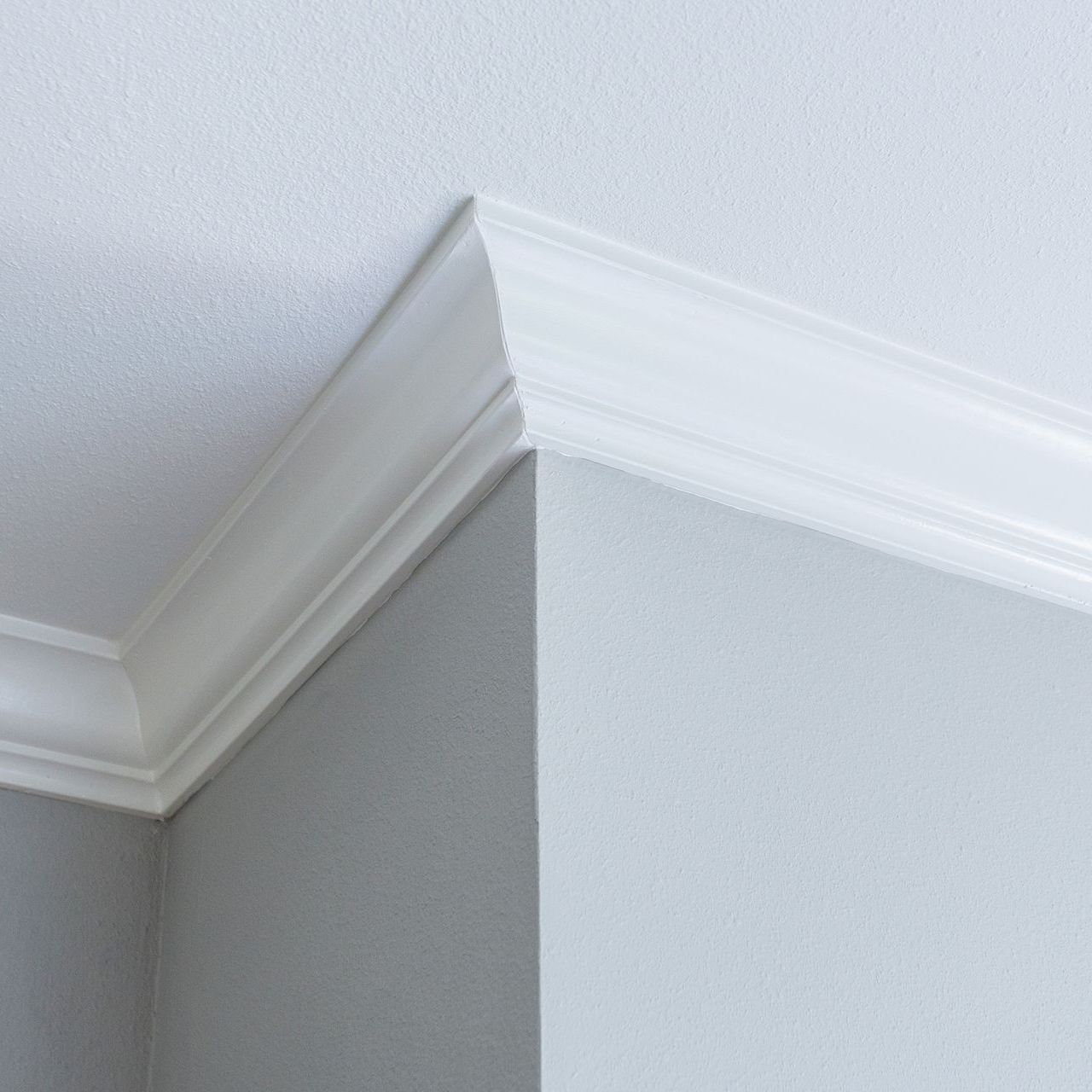 A close up of a white molding on a corner of a wall.