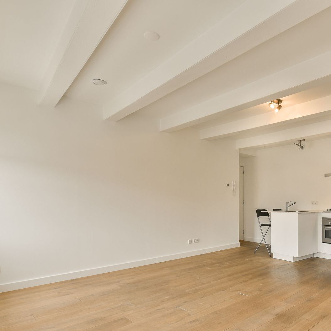 An empty room with a wooden floor and white walls