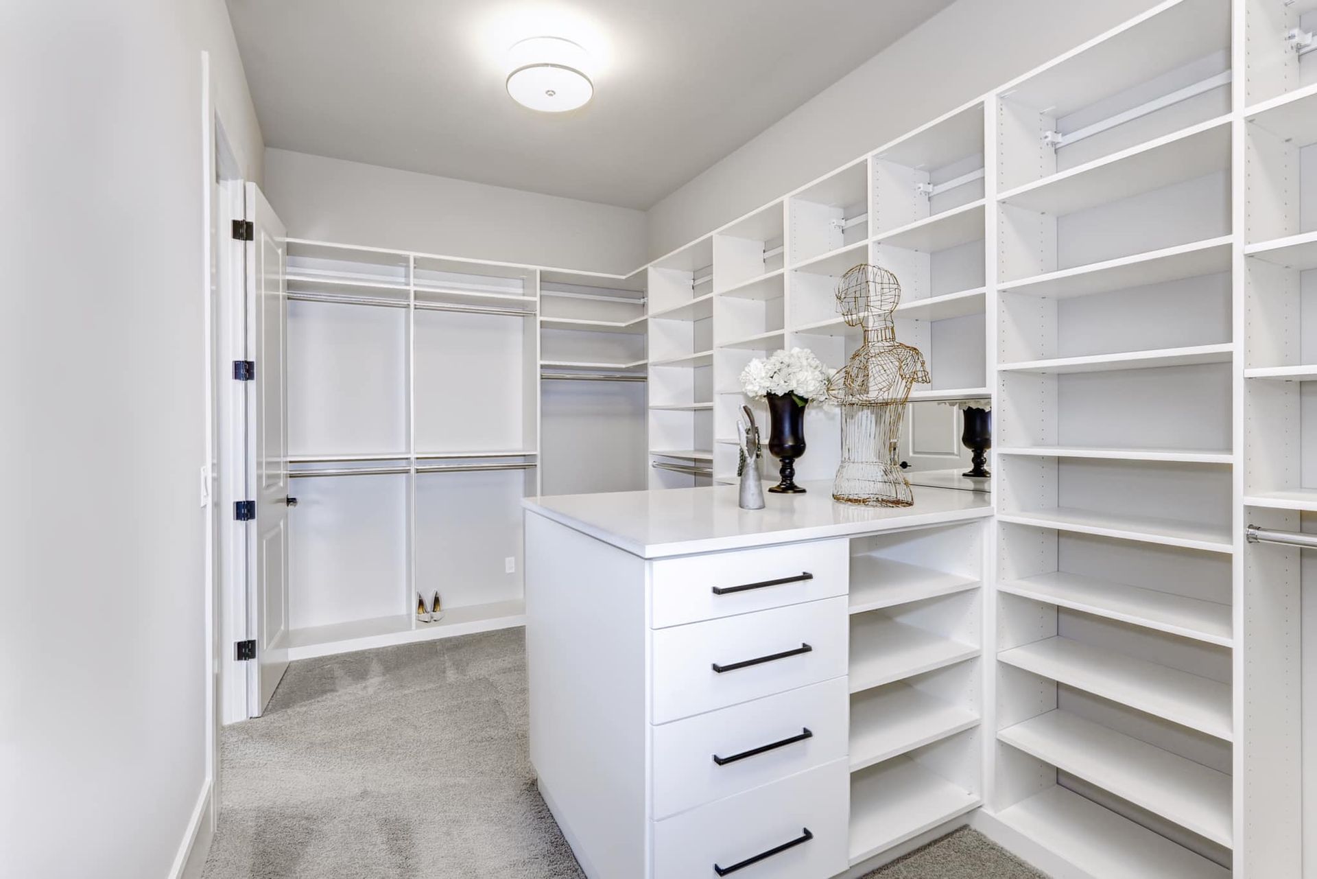 A walk in closet with lots of shelves and drawers.