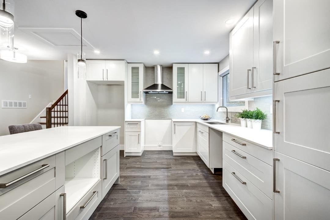 A kitchen with white cabinets and stainless steel appliances