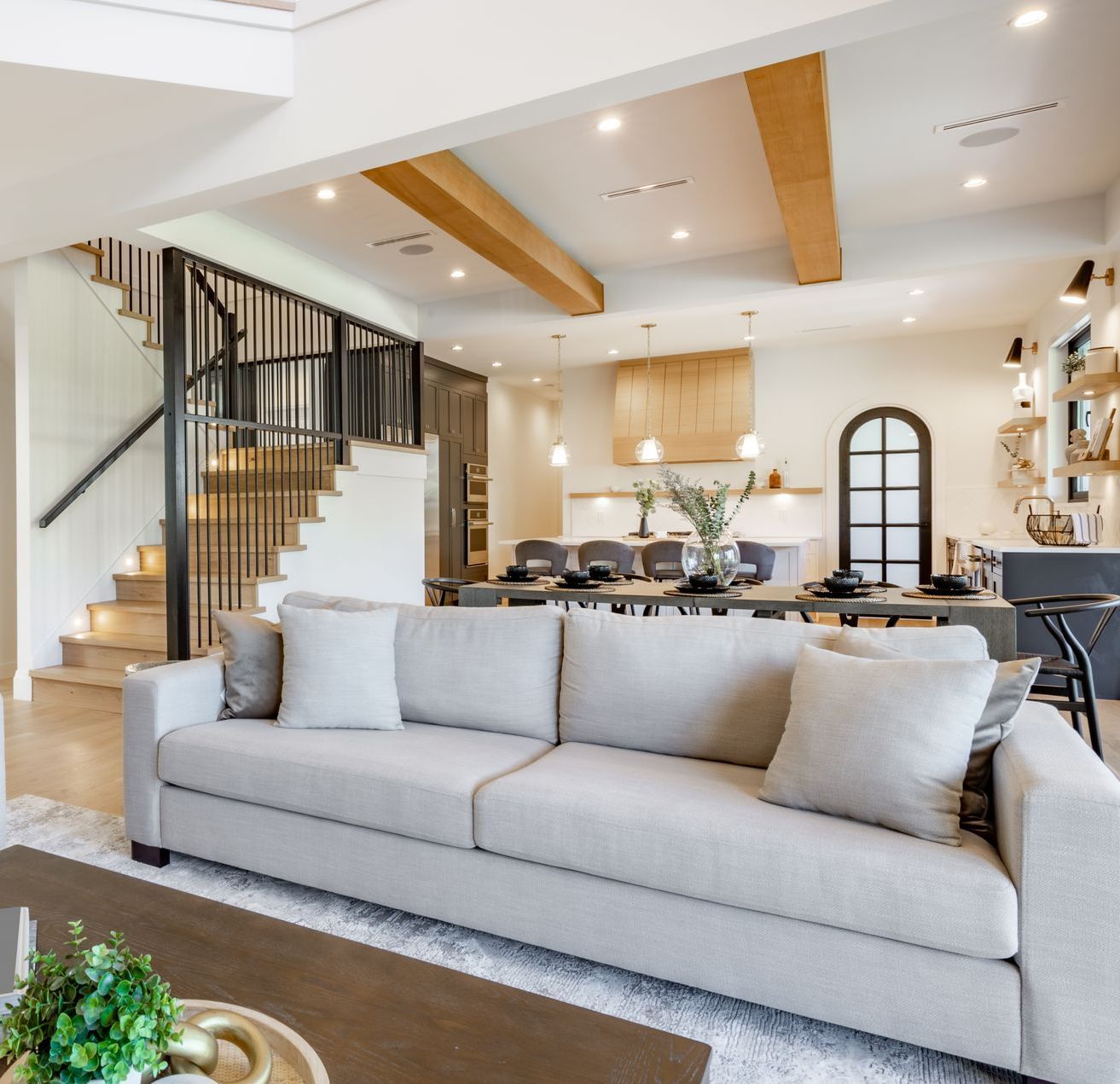 A living room with a couch and stairs in the background