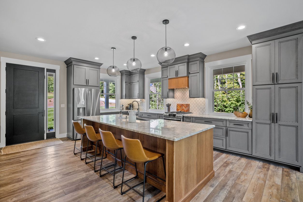 A large kitchen with gray cabinets and a large island.