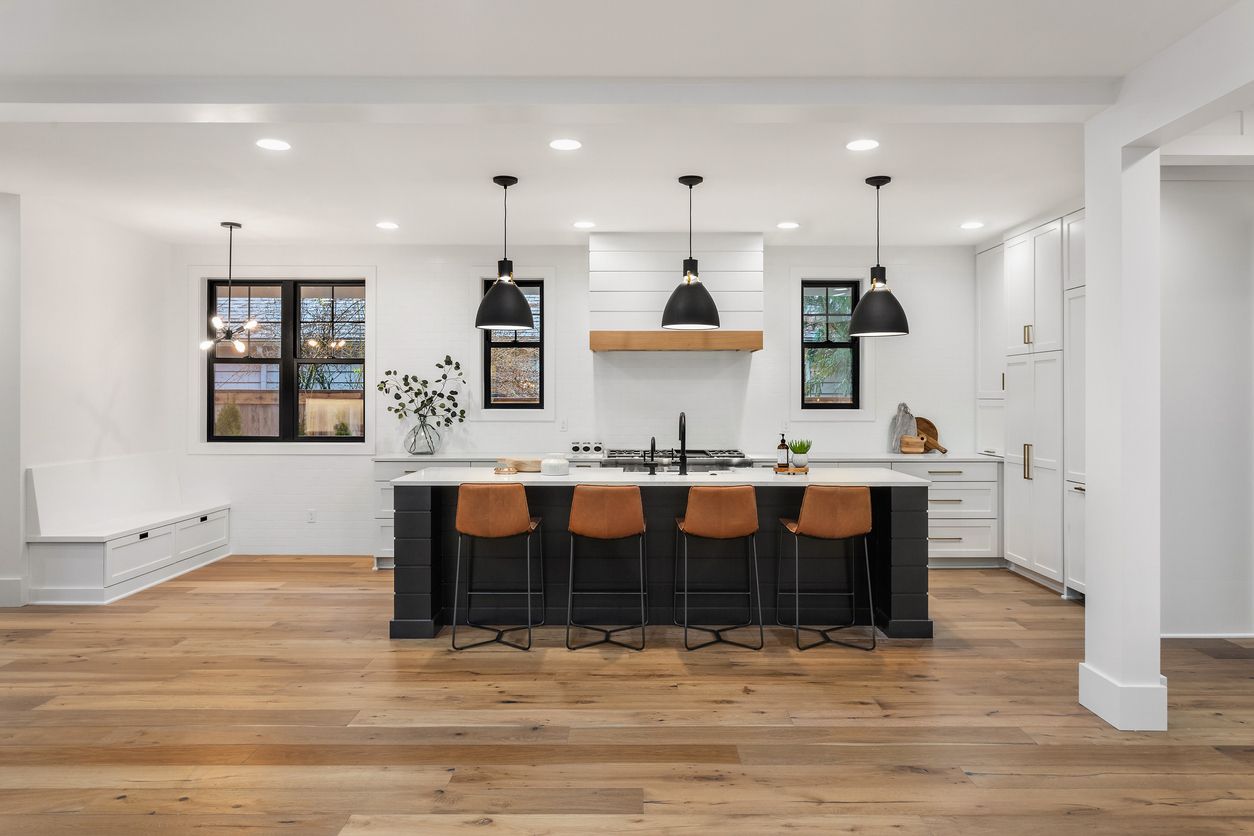 A kitchen with a large island and wooden floors.