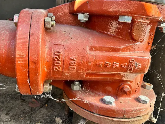 Red metal pipe with bolted flanges, marked