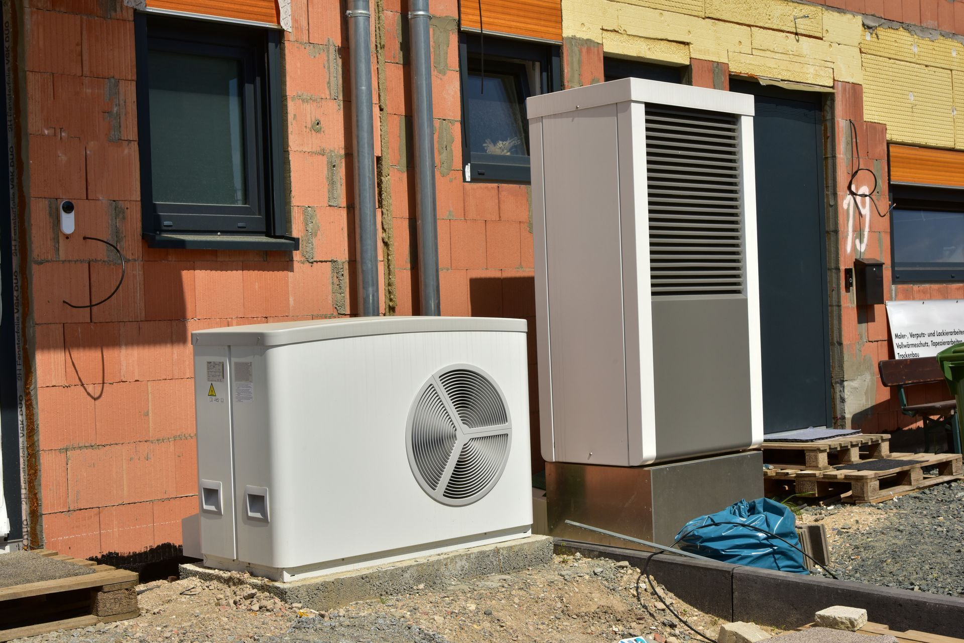 Heat pump outdoor units installed beside a home — Andy's Heating and Cooling serves Omaha, NE homeow