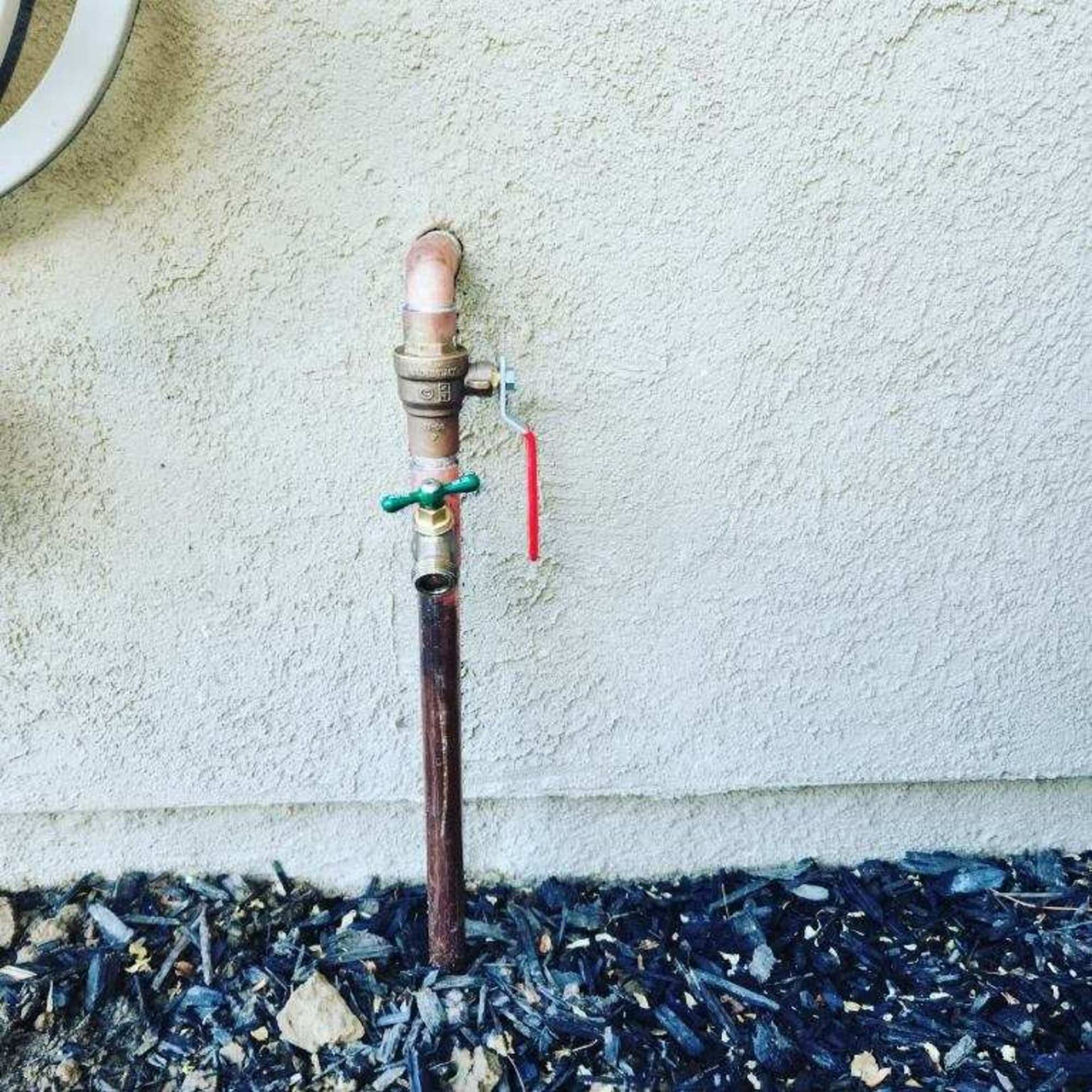 A copper pipe with a green valve attached to it