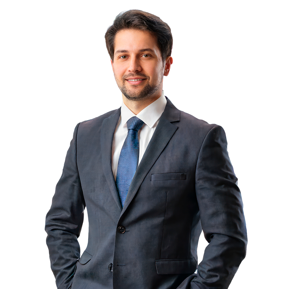 Man in a dark suit and blue tie smiles, posing with hands in pockets. Hercules FX