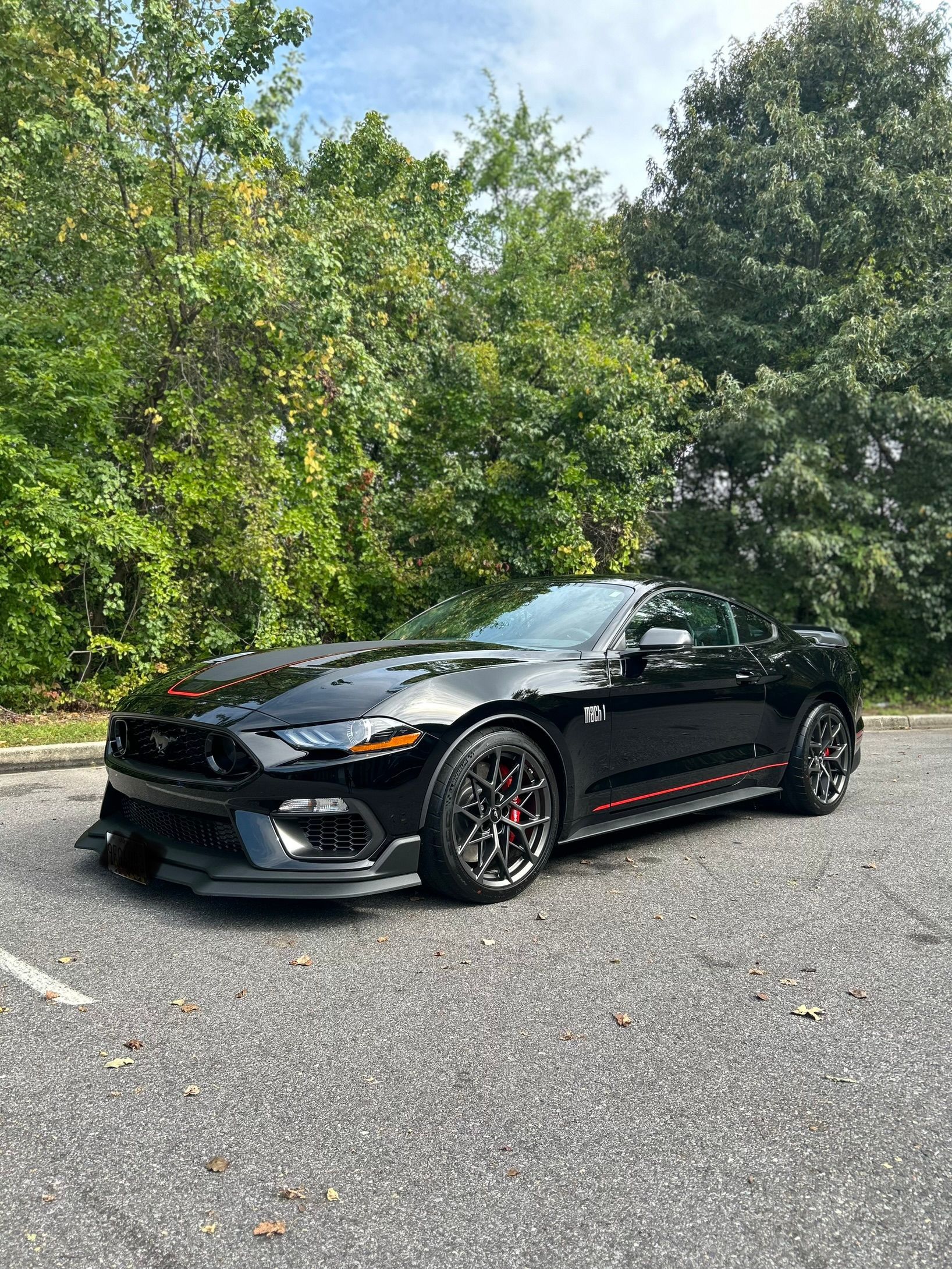 A black ford mustang is parked in a parking lot.