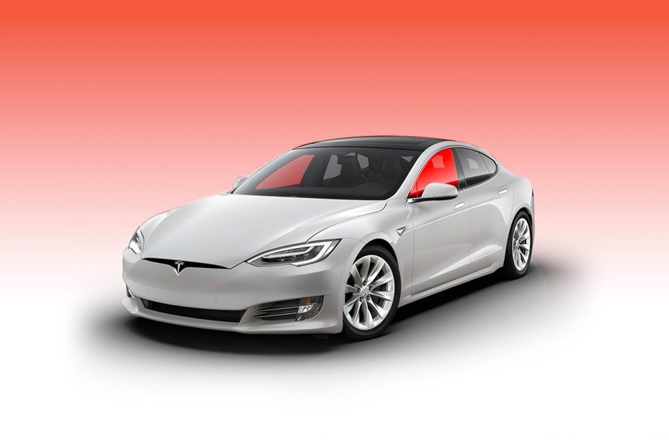 White Tesla sedan with black roof, red-tinted windows, on a gradient red and white background.
