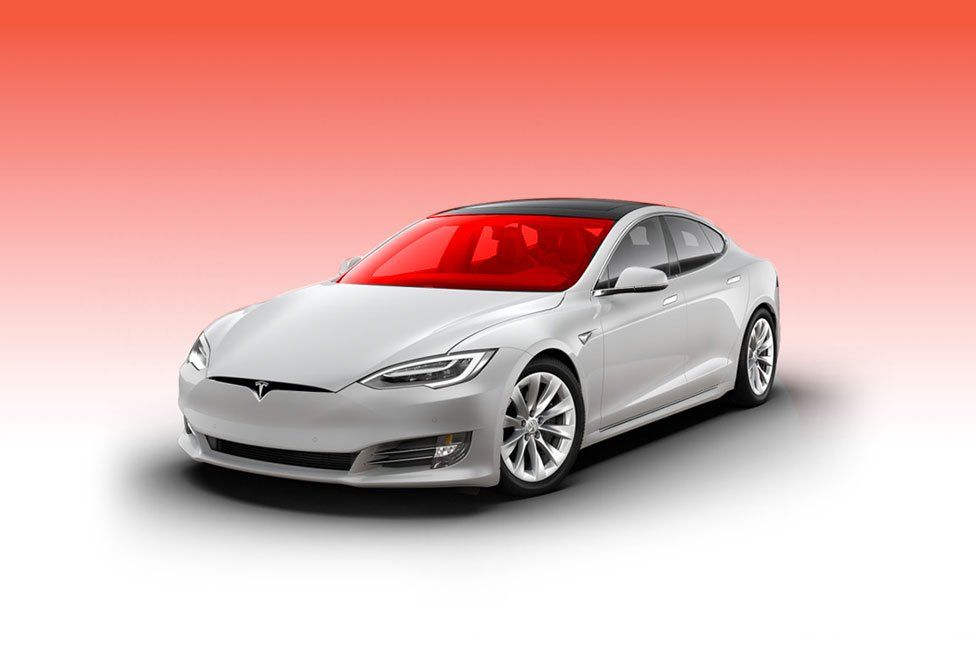 White Tesla sedan with red-tinted windows against a red gradient background.