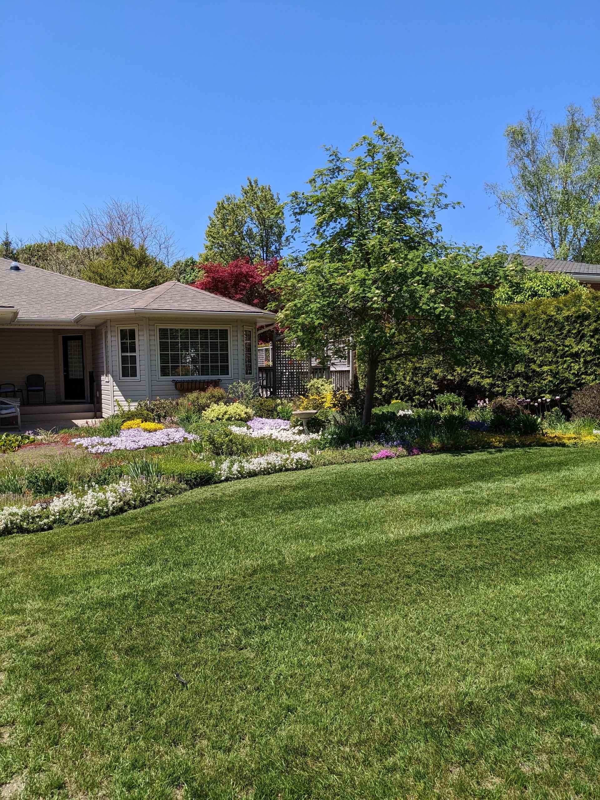 A house with a large lush green lawn in front of it.
