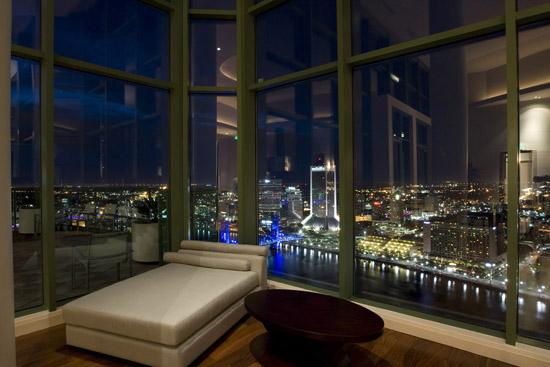 A living room with a view of a city at night.