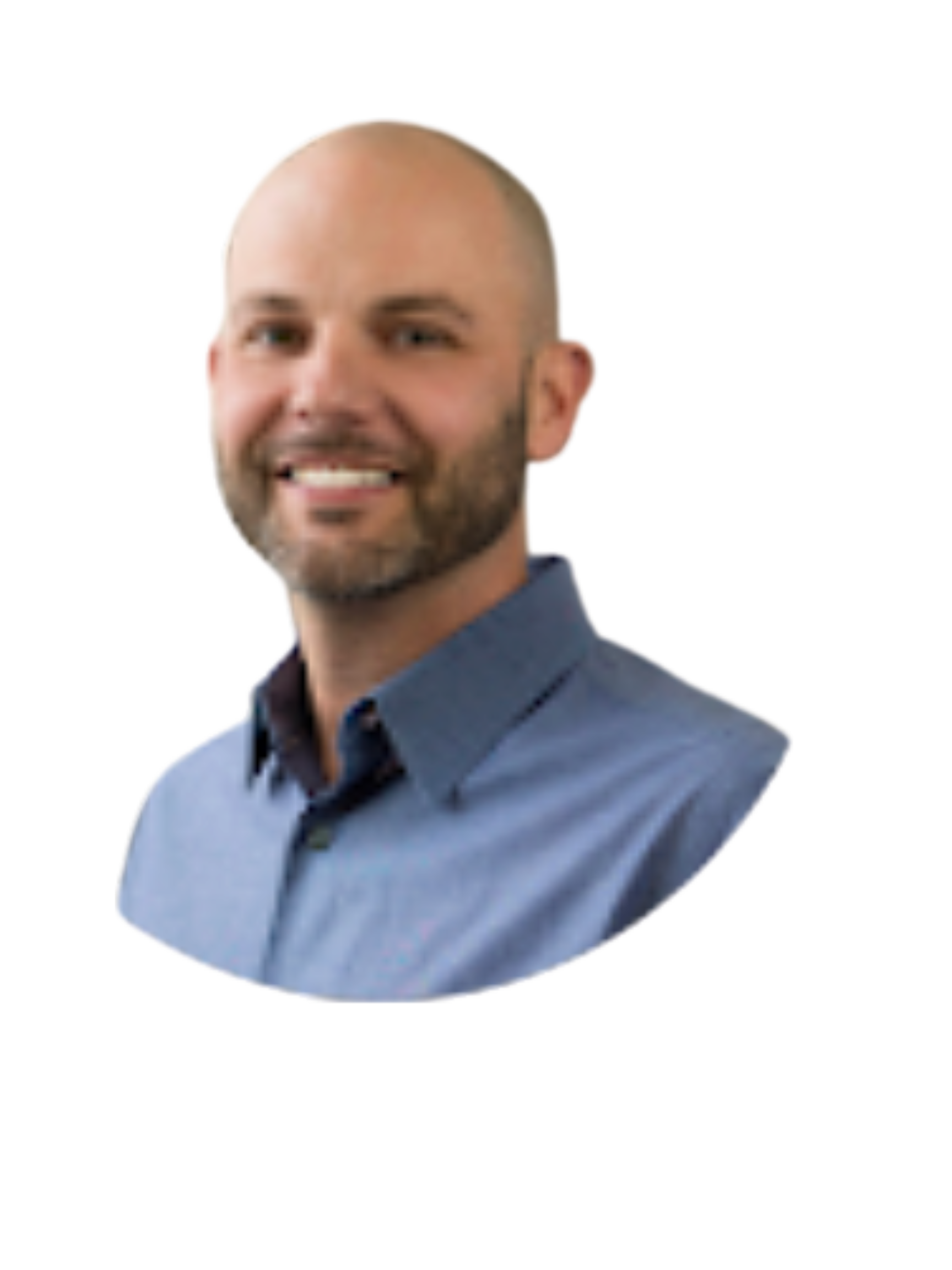 Man with a shaved head and beard smiles while wearing a blue button-down shirt.