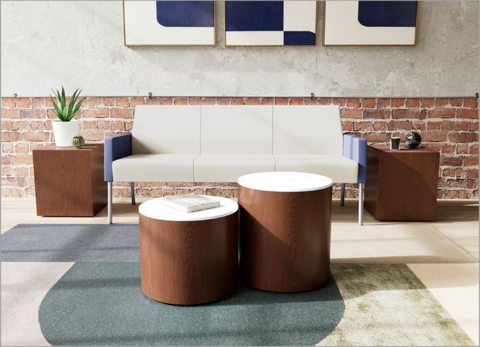 Four colleagues working together at a desk in a bright office.