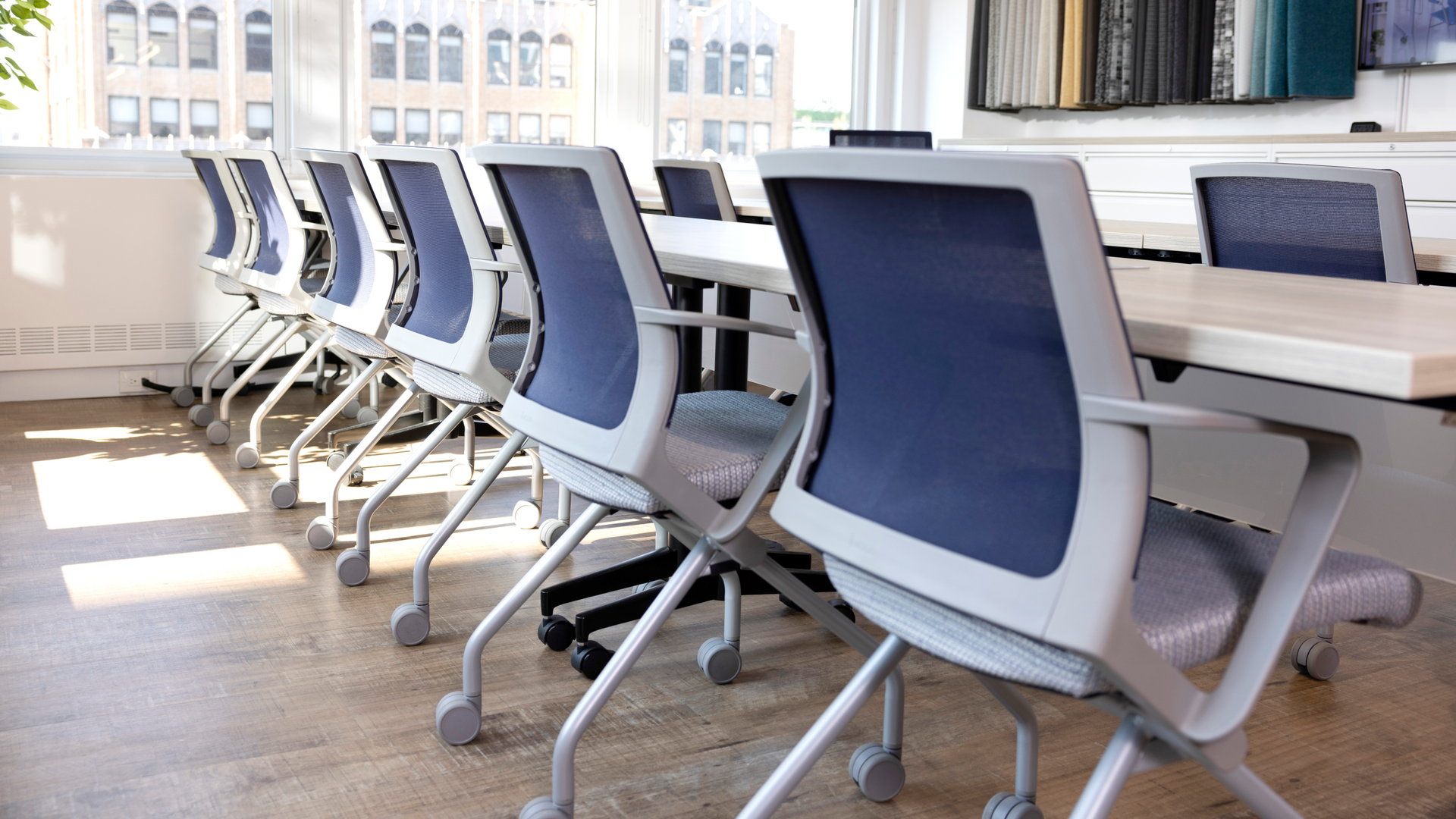 Conference room with a long table and blue-backed office chairs.