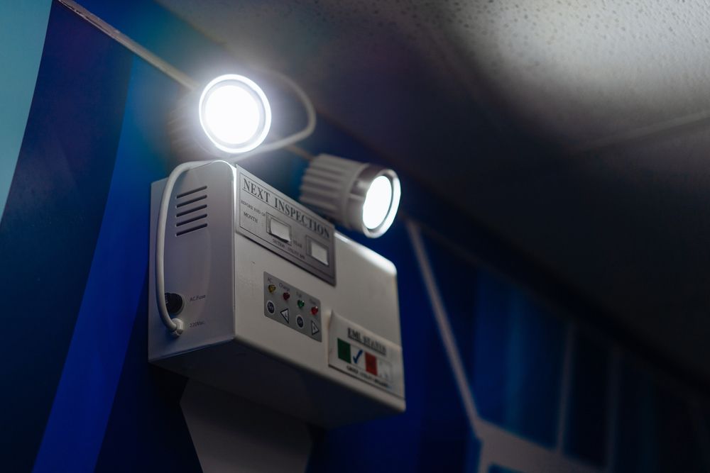 A white box with two lights attached to it is hanging from the ceiling.