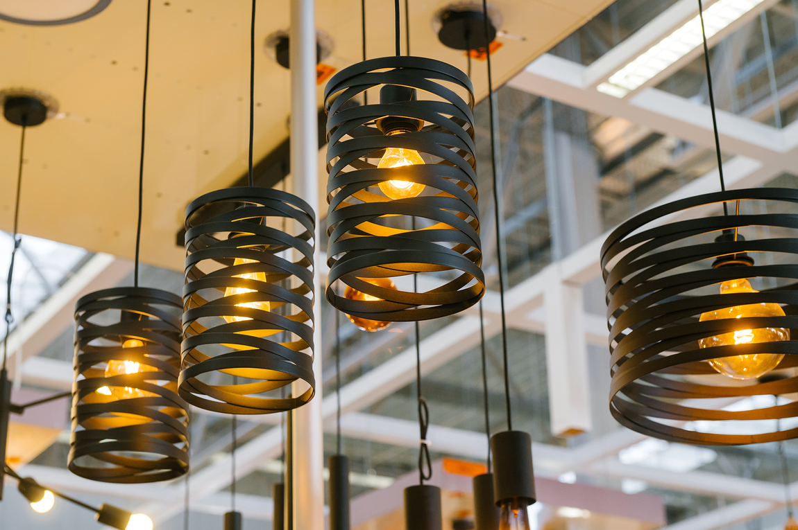 A bunch of lamps are hanging from the ceiling in a room.