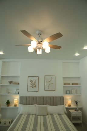 A bedroom with a bed and a ceiling fan.