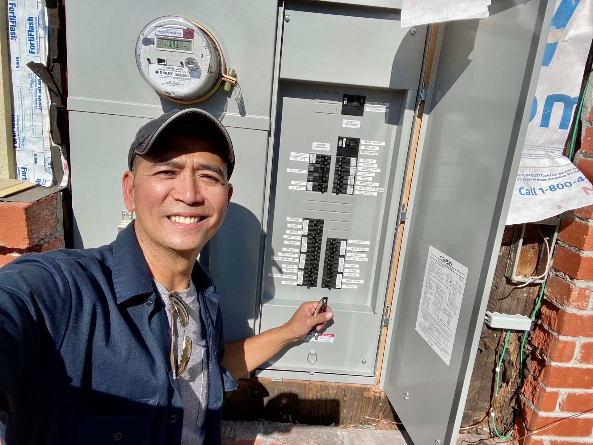 A man is taking a selfie in front of an electrical box.