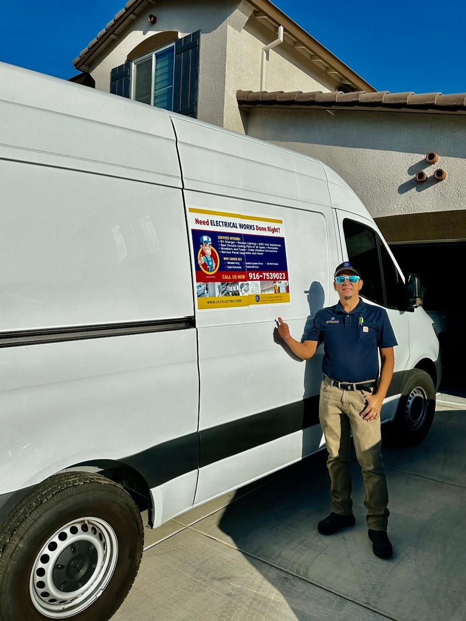 A man is standing next to a white van in front of a house.