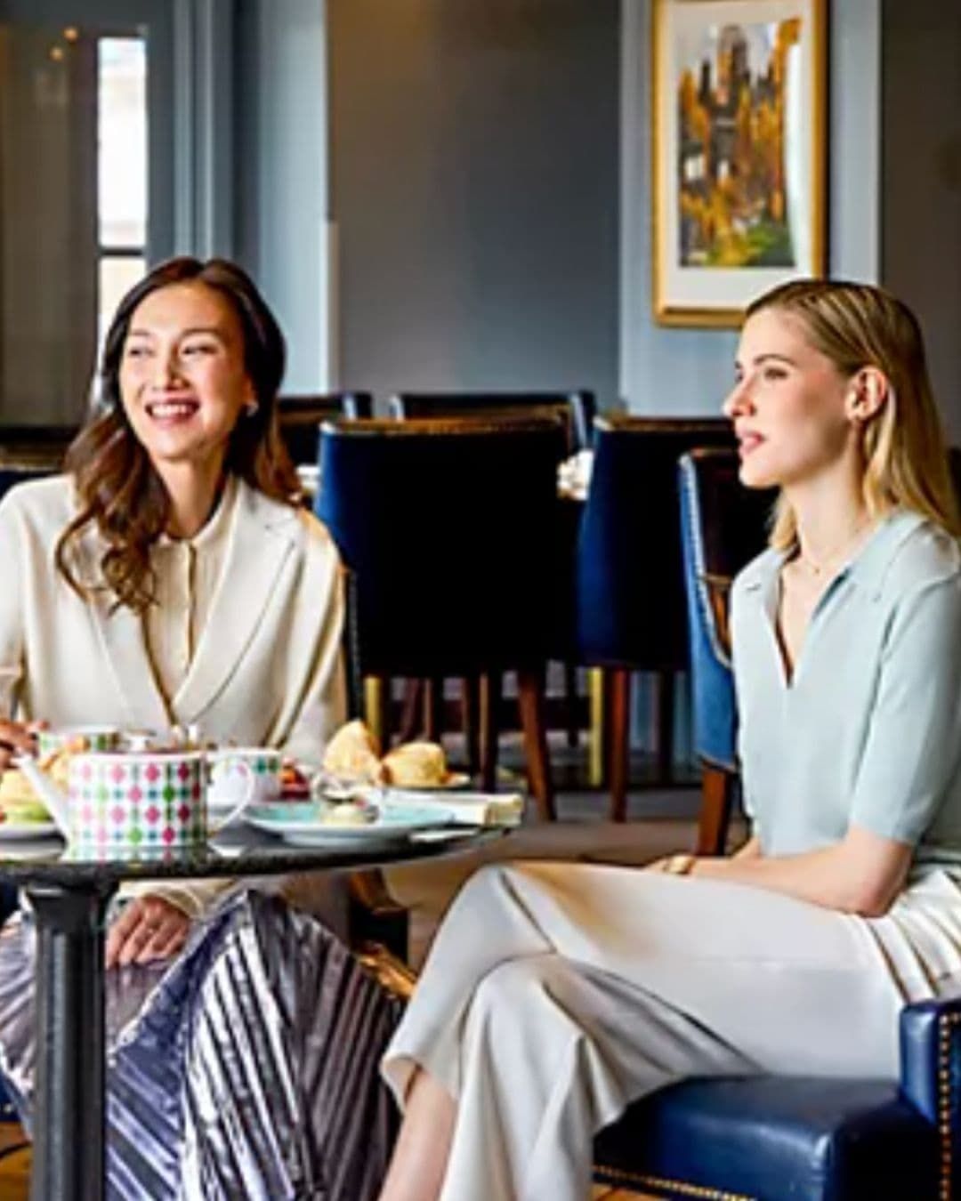 Two women enjoying premium LOT 35 specialty afternoon tea at Place Dufferin restaurant inside Château Frontenac hotel.