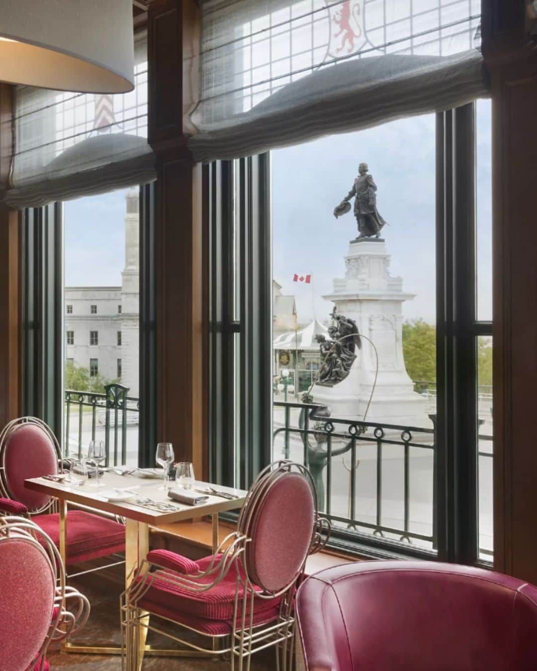 Luxury dining table at Place Dufferin inside Château Frontenac overlooking the historic Champlain Monument in Québec City.