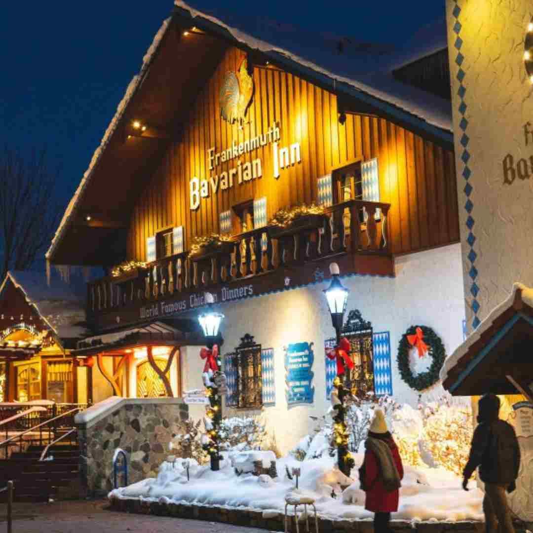 Festive winter scene in downtown Frankenmuth, Michigan, with snow-covered streets, twinkling lights,