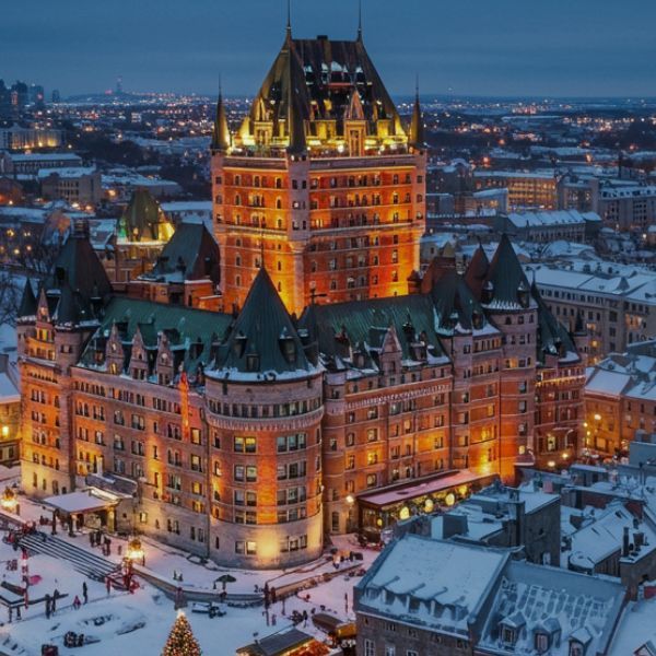 Fairmont Le Château Frontenac in winter with snow-topped turrets.