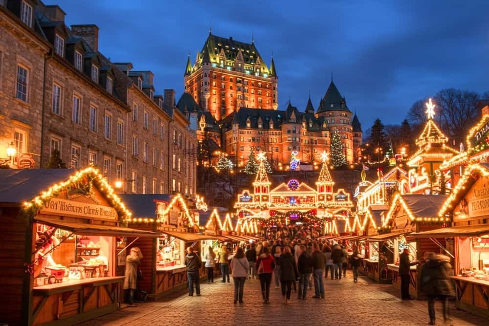 A street musician in Old Quebec plays the accordion for a small crowd of tourists, capturing the festive, European-style atmosphere.