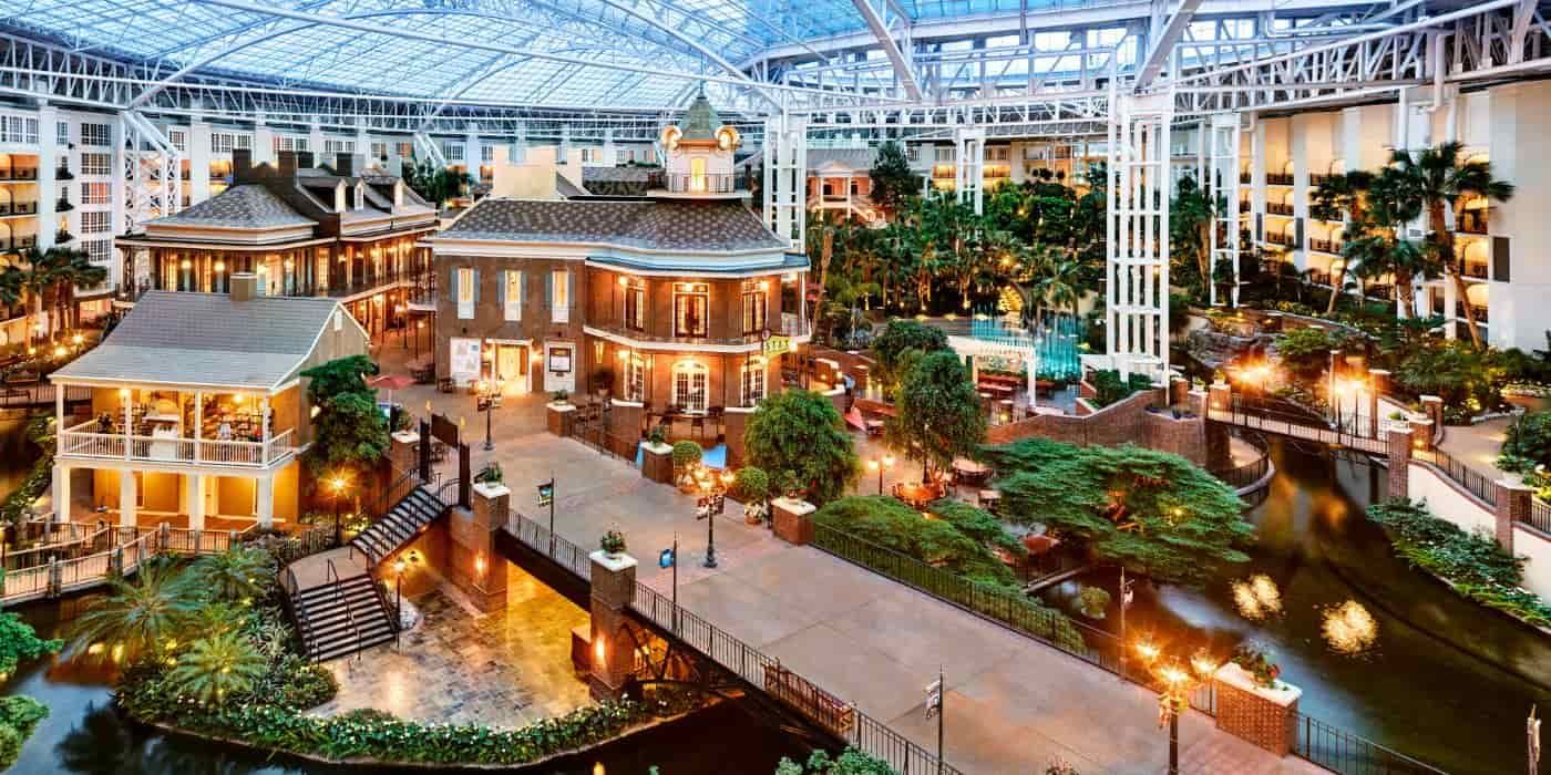 Inside the soaring glass atrium of Gaylord Opryland Resort — lush gardens, winding walkways, and your Nashville home base under one spectacular roof.