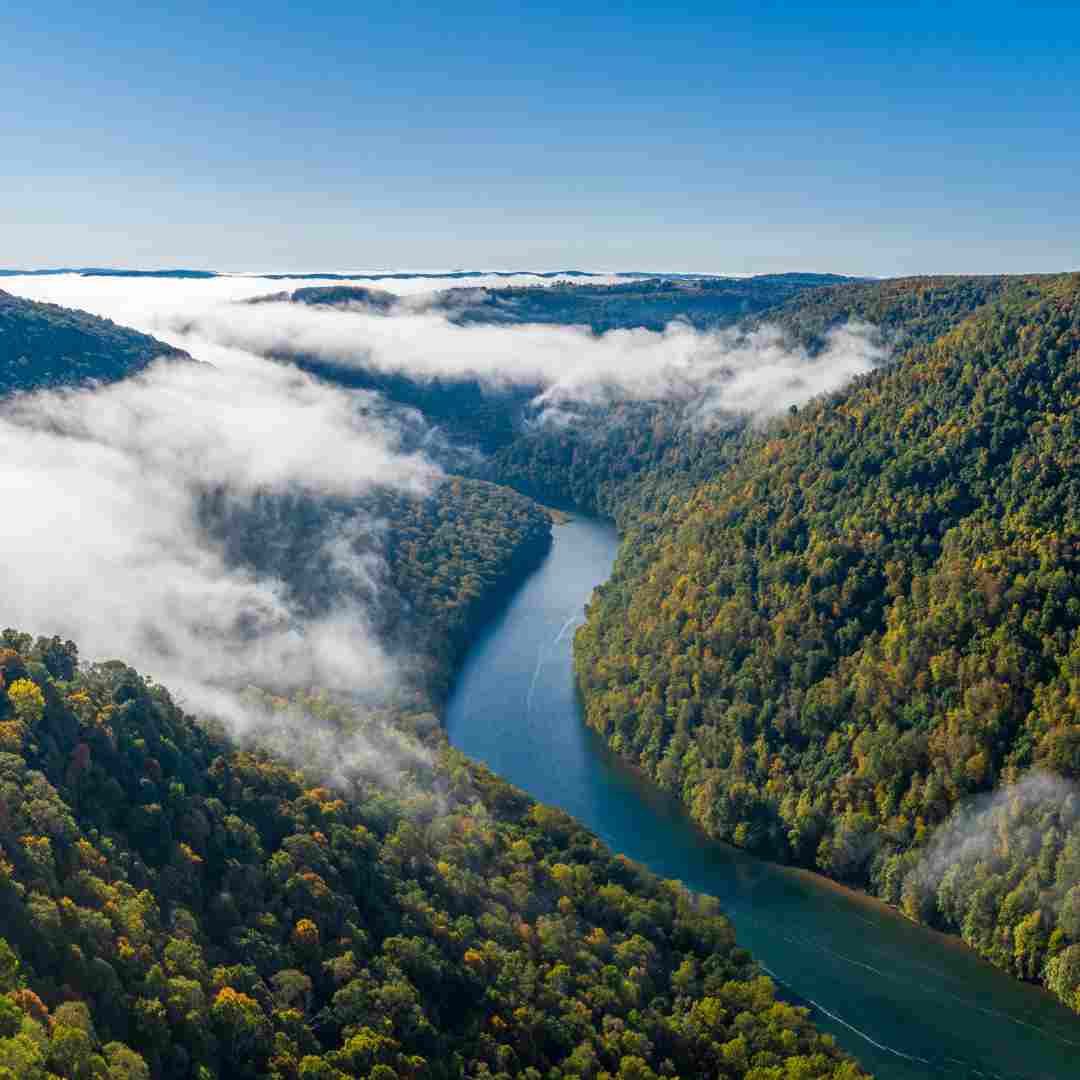 West Virginia. The view from above on the dense forest and a blue river running in the mountains.