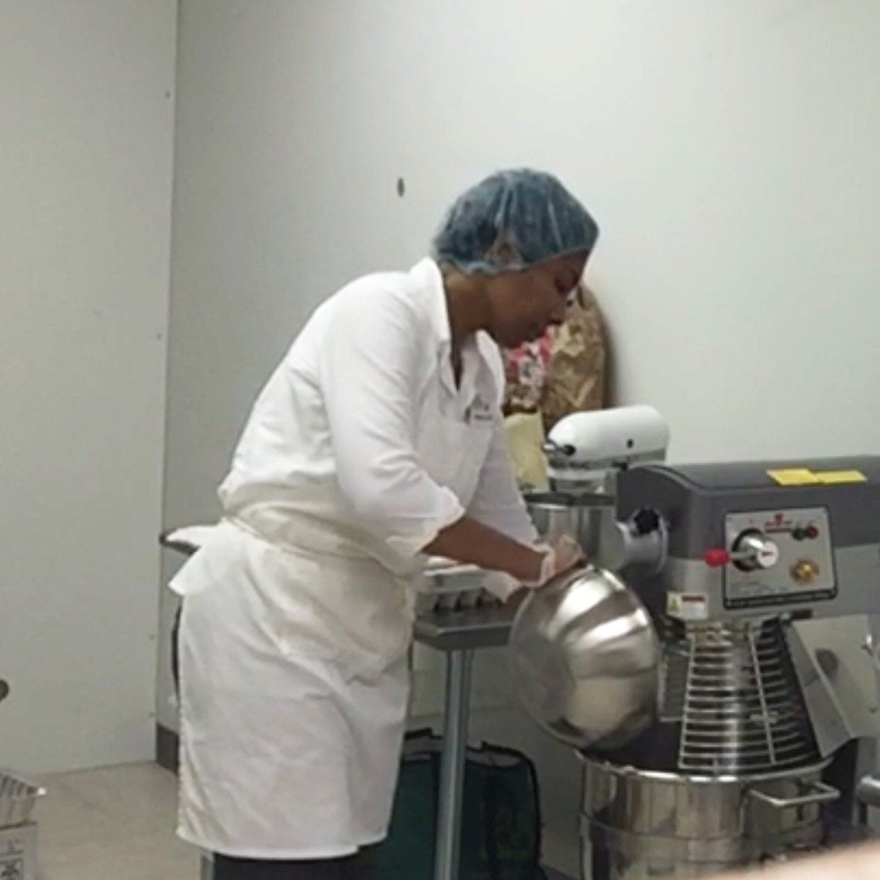 Baker pouring flour into mixer