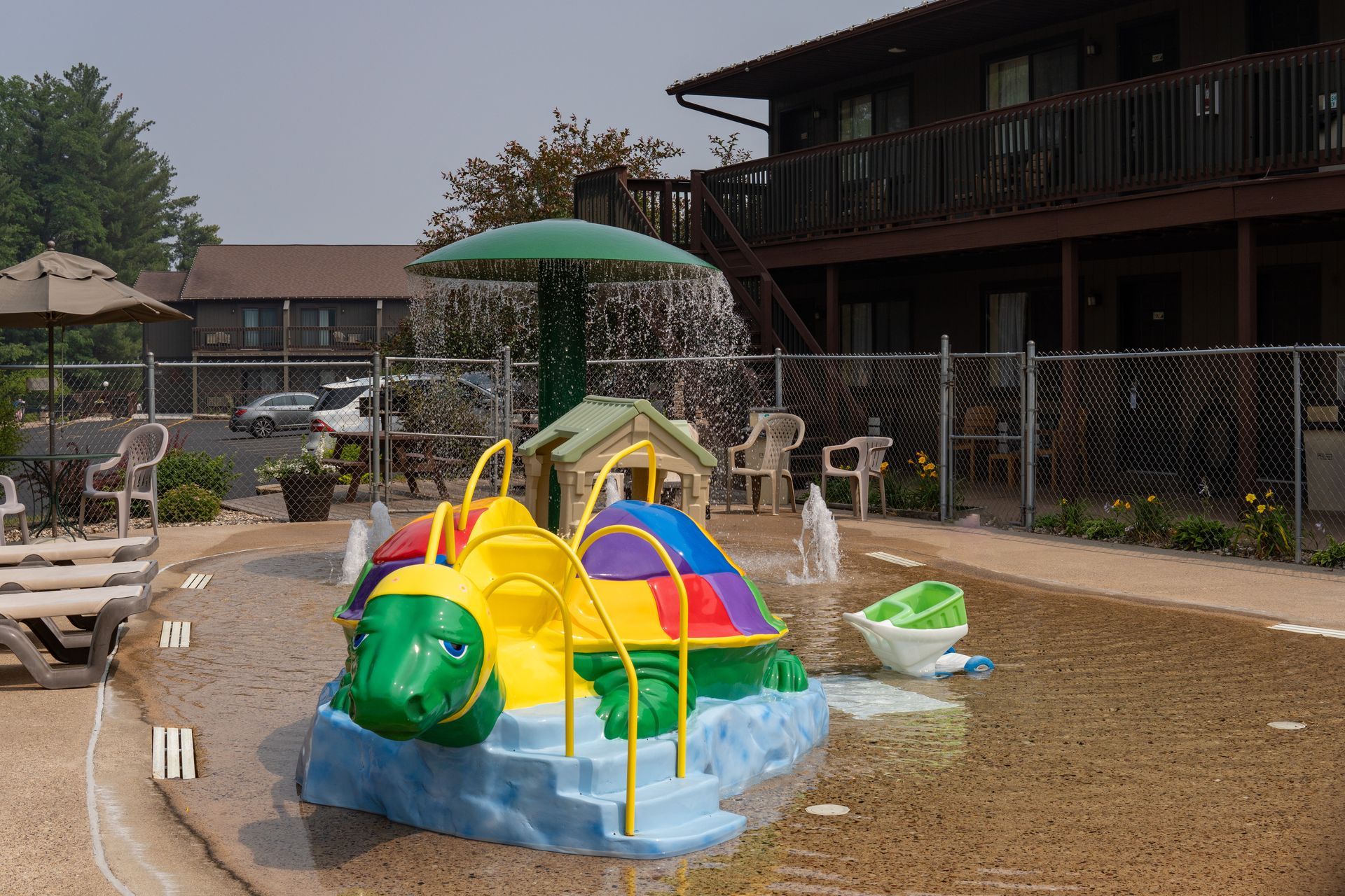 Play area with turtle water feature and surrounding motel buildings.