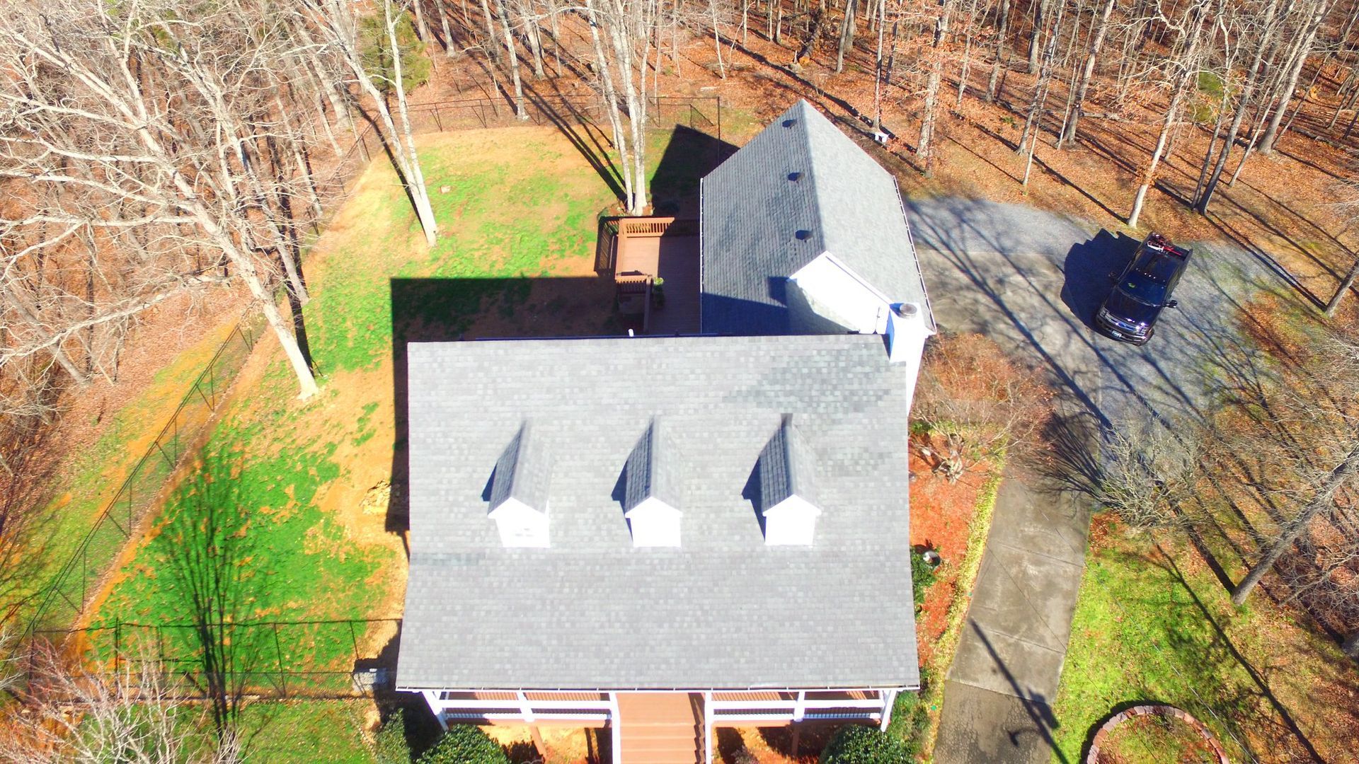 An aerial view of a house in the middle of a forest